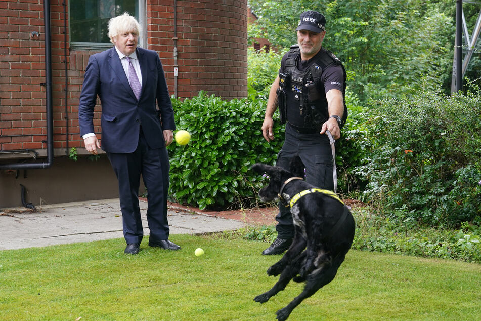 Premier Johnson (l.) sprach bei seinem Besuch des Hauptquartiers der englischen Polizei mit Hundeführer Mike Barnes über die Vierbeiner.