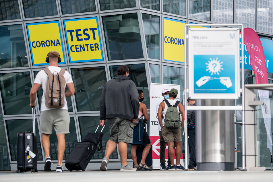 Ankommende Fluggäste gehen zu einem Corona- Testcenter am Flughafen.