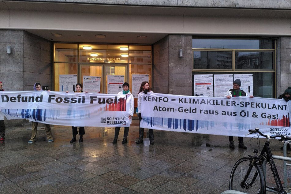 Die Umweltschützer fordern eine "fossilfreie Finanzierung" und halten Banner in die Höhe.