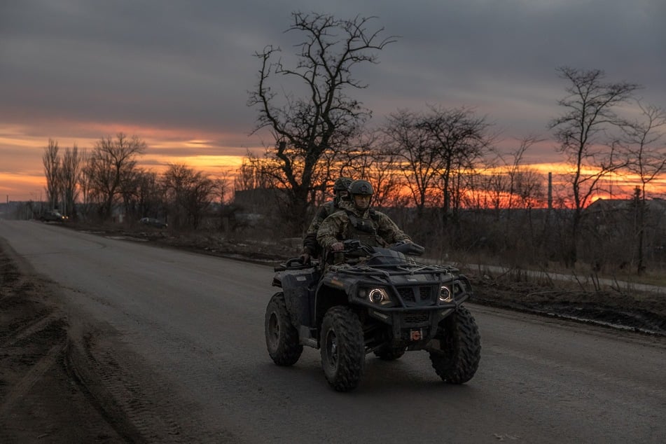 Ukrainische Soldaten patroulieren auf einem Quad eine Straße die nach Tschassiw Jar führt.