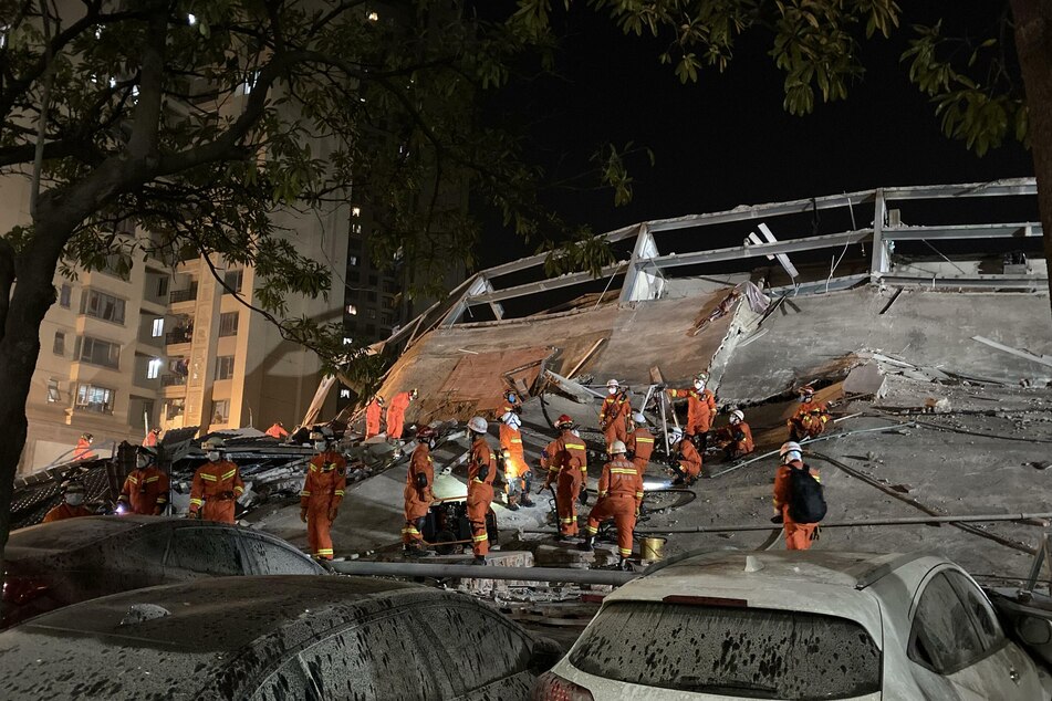 Rettungskräfte arbeiten an der Unfallstelle des eingestürzten Hotelgebäudes.