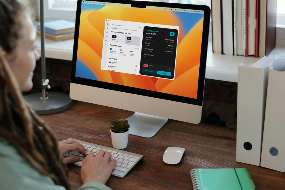 Frau arbeitet an einem iMac, auf dem ein VPN-Programm