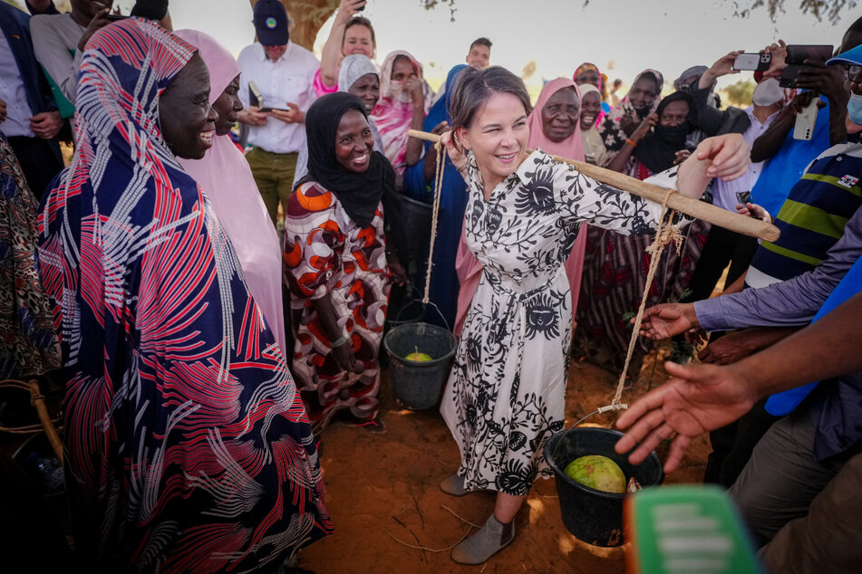 Annalena Baerbock trägt Melonen auf den Schultern. Die Ministerin lässt sich zeigen, welche Lasten Frauen bei der Hitze tragen müssen.