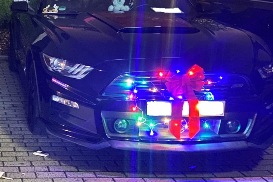 Eines der Autos war an der Front mit einer Lichterkette und einer großen roten Schleife verziert.