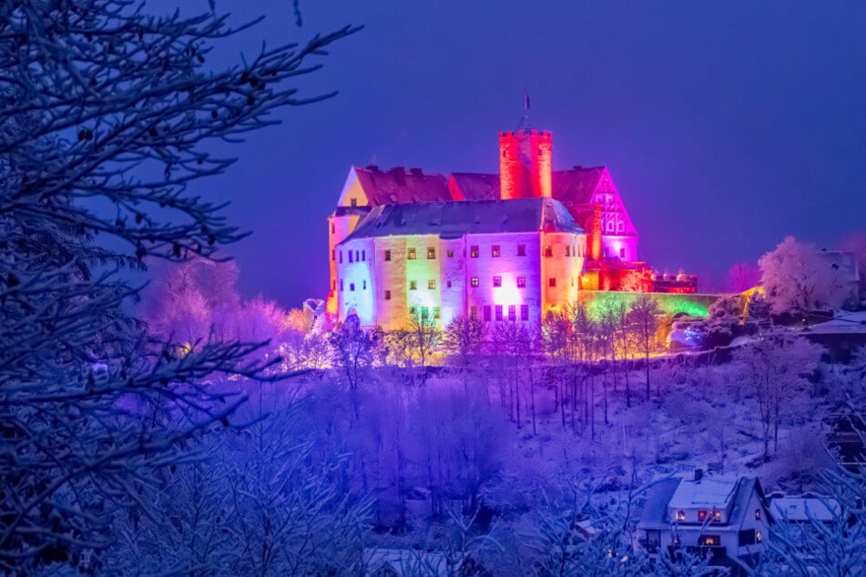 Der Polarzauber Scharfenstein lässt die Burgfassade in bunten Farben der Nordlichter erleuchten.