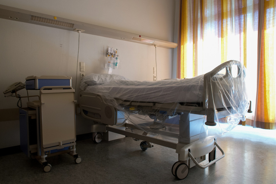 Ein mit Folie überzogenes Bett steht in einem Krankenhauszimmer.