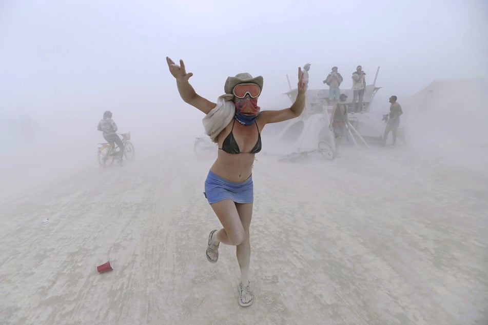 Eine Frau tanzt während eines Sandsturms beim Burning-Man-Festival 2017. Aufgrund der Corona-Pandemie ist das legendäre Festival erneut abgesagt worden.