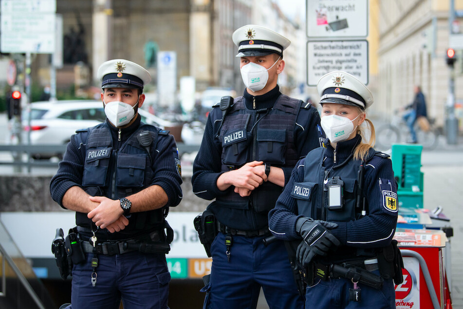 Polizisten kontrollieren im Rahmen eines bundesweiten Aktionstages an der U-Bahnstation Odeonsplatz die Einhaltung der Maskenpflicht in München.