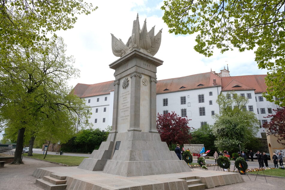 Das Denkmal der Begegnung mit dem Schloss Hartenfels im Hintergrund spielt geschichtlich eine wichtige Rolle.