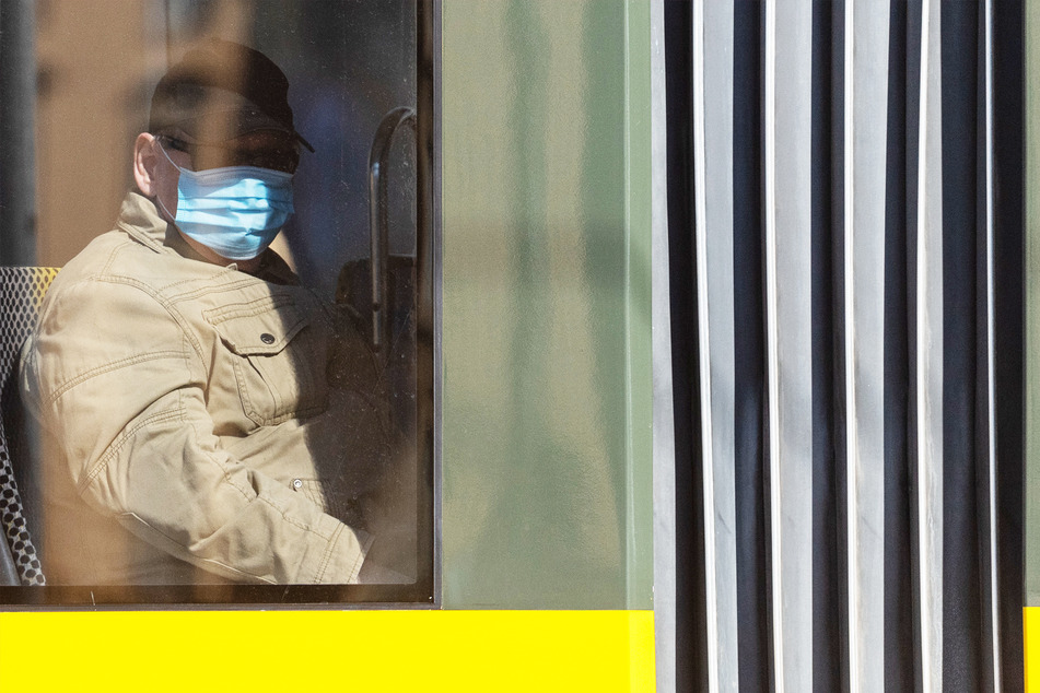 Ein Mann fährt mit Schutzmaske in einer Dresdner Straßenbahn. Eine derartige Pflicht besteht dort seit Montag.