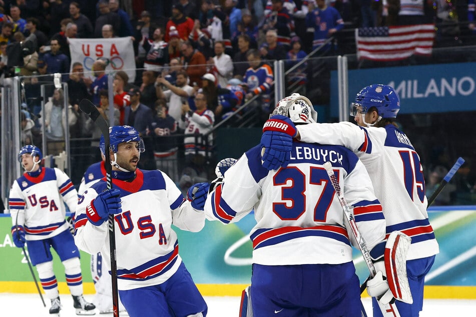 Vincent Trocheck, Connor Hellebuyck, and Noah Hanifin of the US celebrate after the match against Slovakia at the Milano Santagiulia Ice Hockey Arena on February 20, 2026.