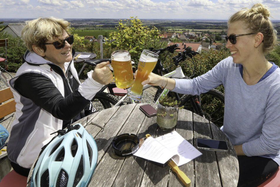 Mutter und Tochter sitzen im Biergarten und prosten sich mit einem Glas Bier zu. Im Südwesen soll es bald noch mehr Corona-Lockerungen geben. (Symbolbild)
