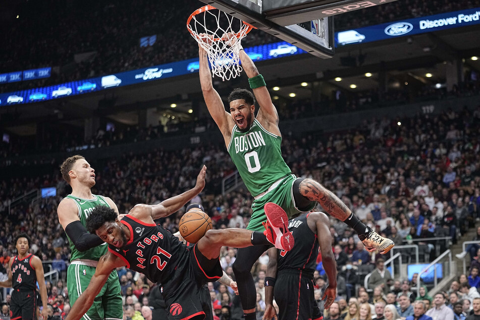 Boston Celtics forward Jayson Tatum dunks against Toronto Raptors forward Thaddeus Young during the first half at Scotiabank Arena.