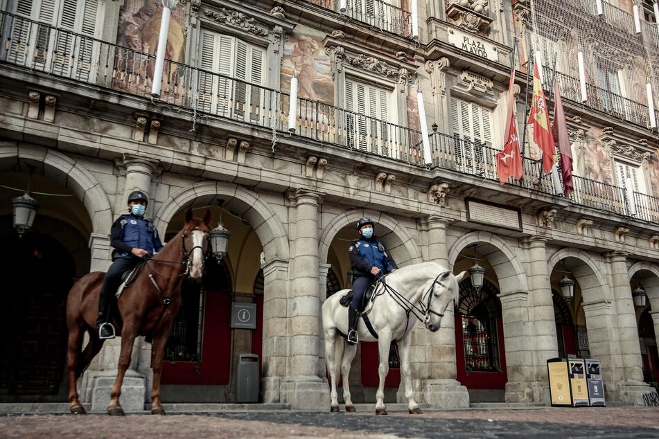 Spanien, Madrid: Berittene Polizisten patroullieren auf dem Plaza Mayor, nach dem Inkrafttreten neuer Beschränkungen.