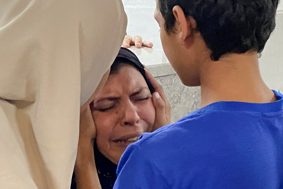 The mother of Palestinian Mohammed Abu Amira, who was killed in an Israeli strike, is comforted by her son at Al-Shifa hospital in Gaza City.