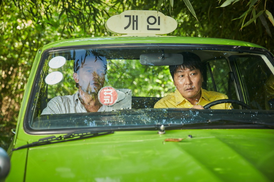 Thomas Kretschmann (l.) und Song Kang-ho begeben sich in "A Taxi Driver" auf eine gemeinsame Taxifahrt.