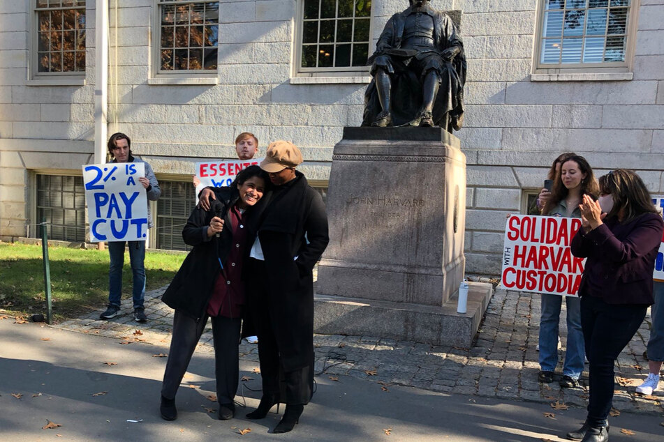 Doris receives a hug from Massachusetts Rep. Ayanna Pressley at a Raise the Wage rally for essential workers at Harvard University.