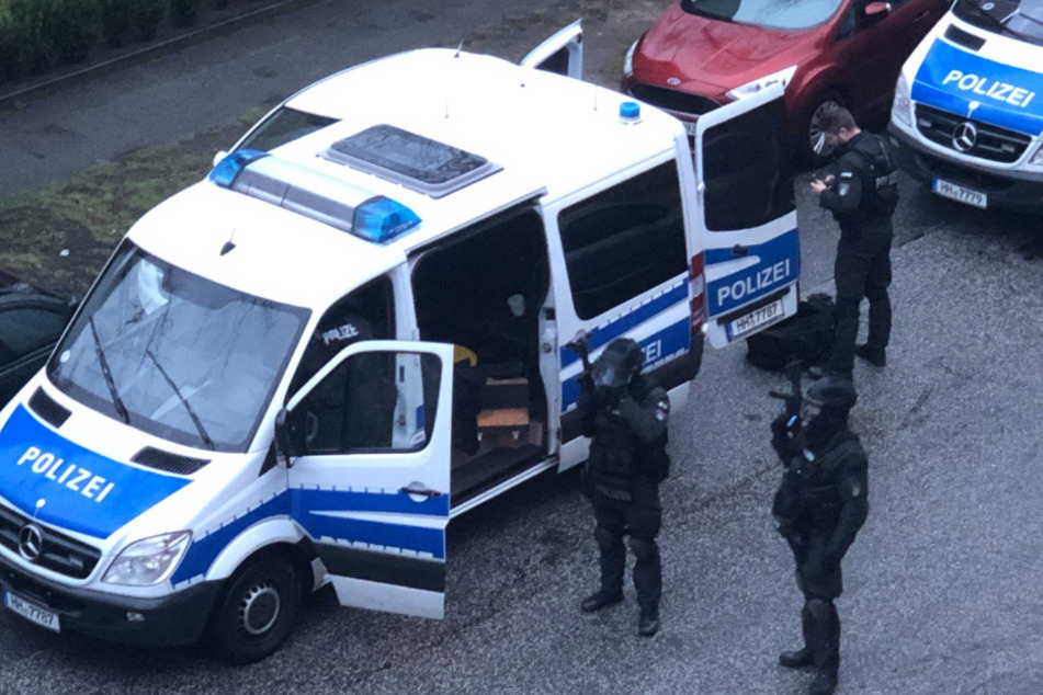 Bewaffnete Polizisten stehen während des Einsatzes auf der Straße in Borgfelde.