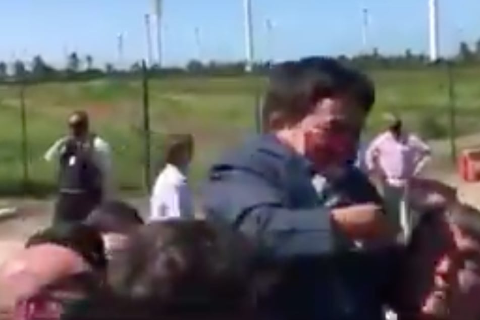 Jair Bolsonaro (r.) picks up a small person he mistook for a child.
