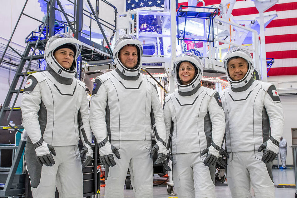 Mission Specialist Anna Kikina from Roscosmos; Pilot Josh Cassada and Commander Nicole Aunapu Mann, both from NASA; and Mission Specialist Koichi Wakata from JAXA pose in their Crew Dragon flight suits at SpaceX headquarters in Hawthorne, California.
