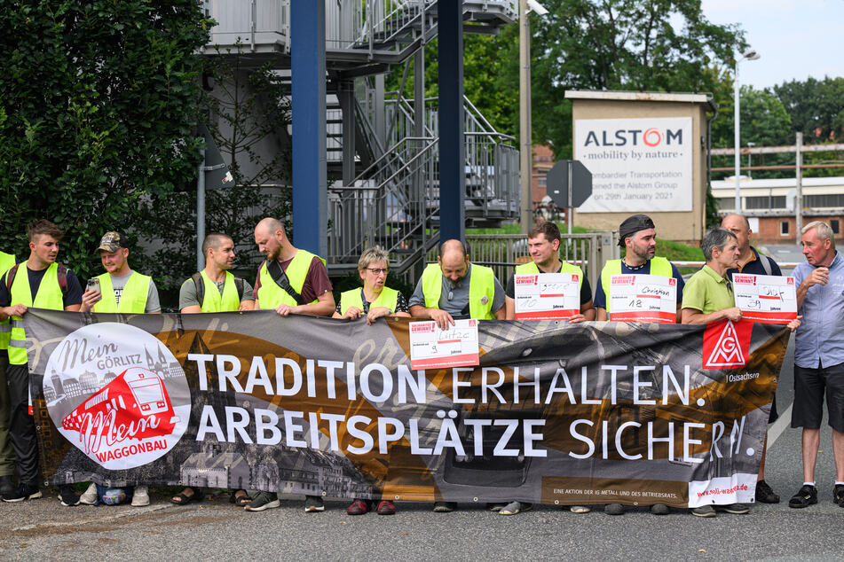 Mit einer Menschenkette vor dem Alstom-Werk in Görlitz protestieren Beschäftige gegen die geplanten Stellenstreichungen in den sächsischen Werken.