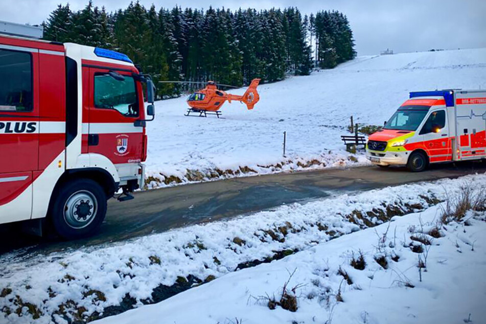 Die Feuerwehr, der Rettungs-Hubschrauber und ein Krankenwagen stehen am Rodelhang an dem das Unglück passierte.