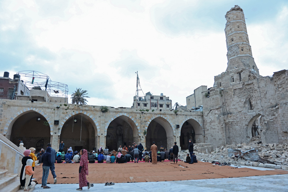 Palestinians in Gaza City gather for Eid in the ruins of the Omari Mosque, partially destroyed by Israeli attacks.
