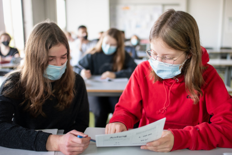 Zwei Schülerinnen mit Mund- und Nasenschutz im Unterricht.