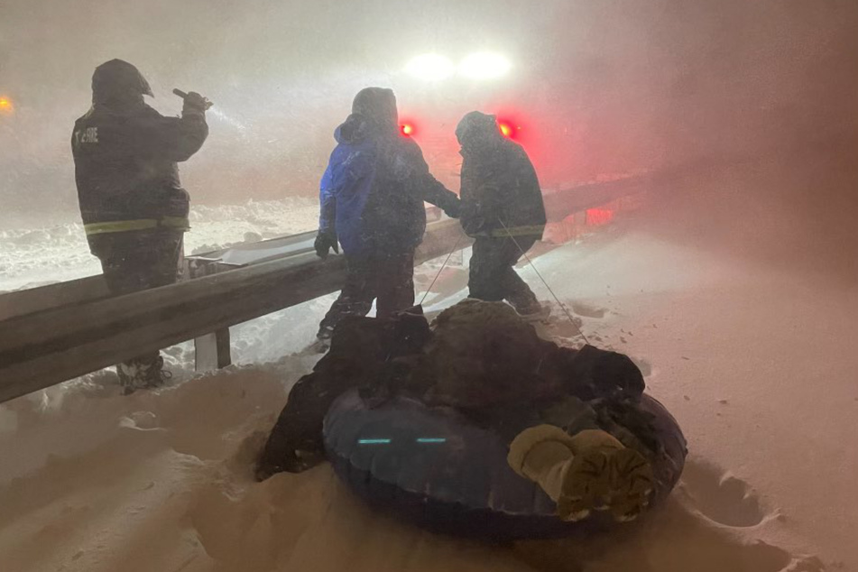 Rettungskräfte in Buffalo retten zwei Personen aus ihren eingeschneiten Autos und bringen sie in Sicherheit. Anndel hatte weniger Glück, für sie kam jede Hilfe zu spät.