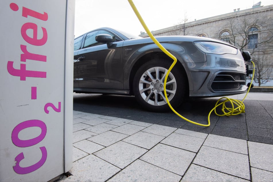 Ein Elektroauto von Audi wird mit einem Kabel an einer E-Ladesäule aufgeladen.