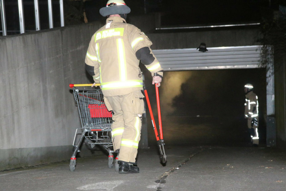 Ein Feuerwehrmann geht in die stark verrußte Tiefgarage.