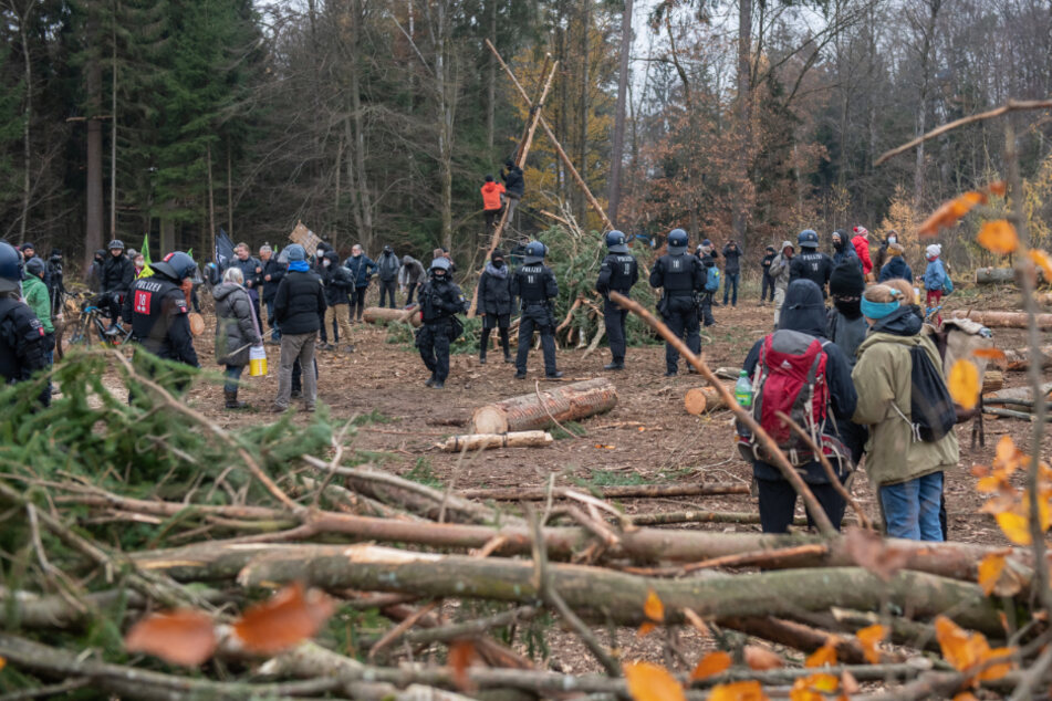 Demonstranten und Polizisten stehen im Dannenröder Forst.