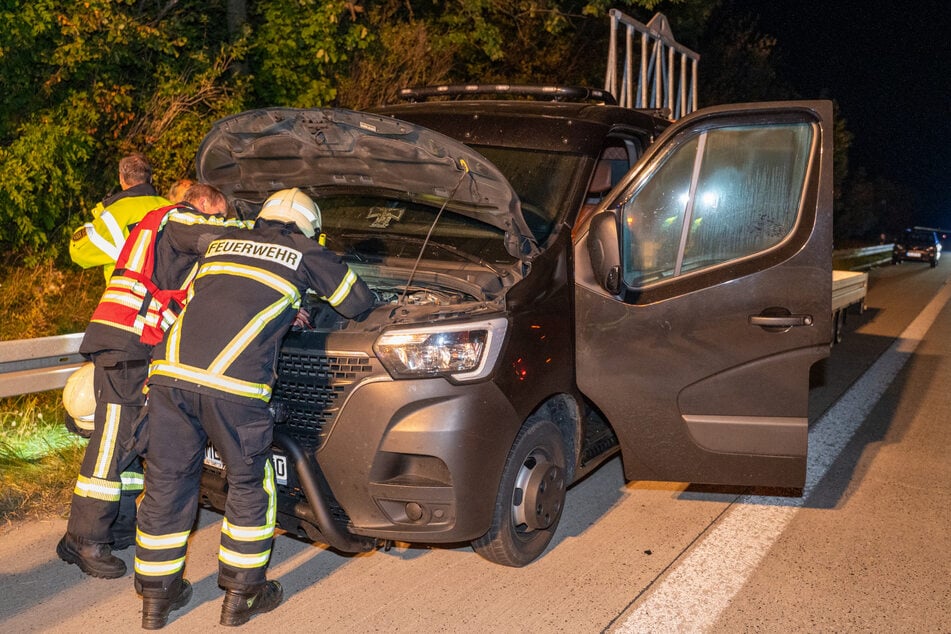Kameraden der Feuerwehr bauten die Fahrzeugbatterie aus, die wahrscheinlich den Brand im Wagen ausgelöst hatte.