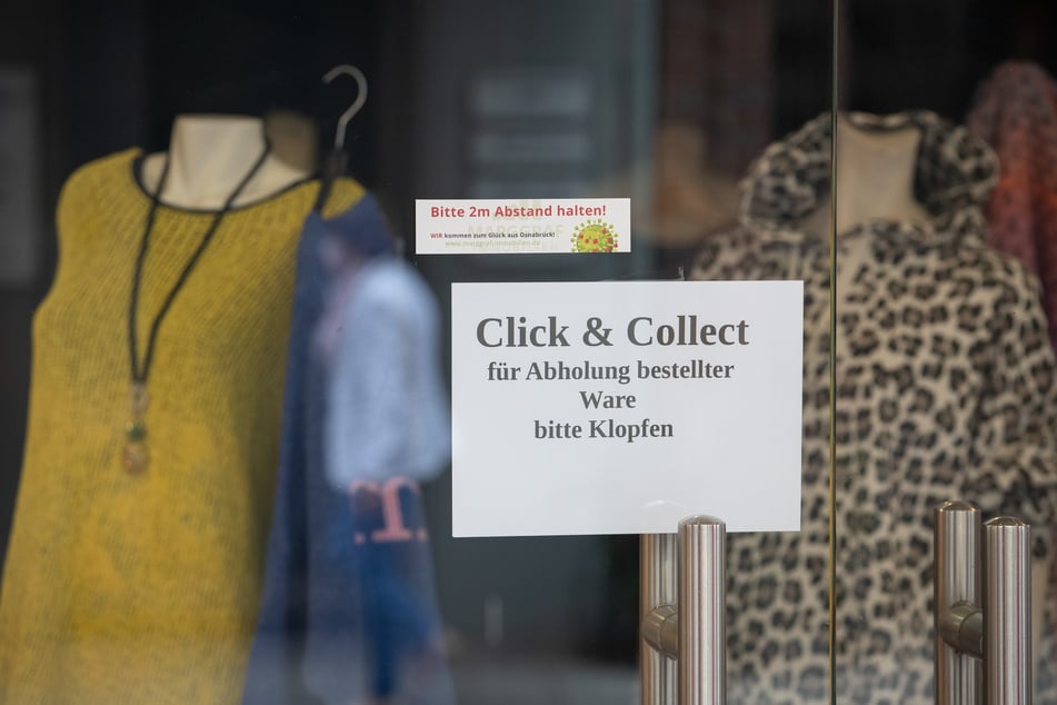 Mit einem "Click &amp; Collect"-Schild wirbt ein Modegeschäft für die Abholung bestellter Ware.