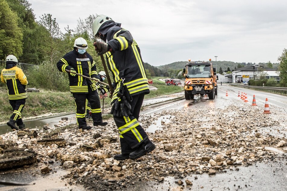 Auf der B19 bei Königsbronn: Einsatzkräfte der Feuerwehr fegen Geröll zusammen.