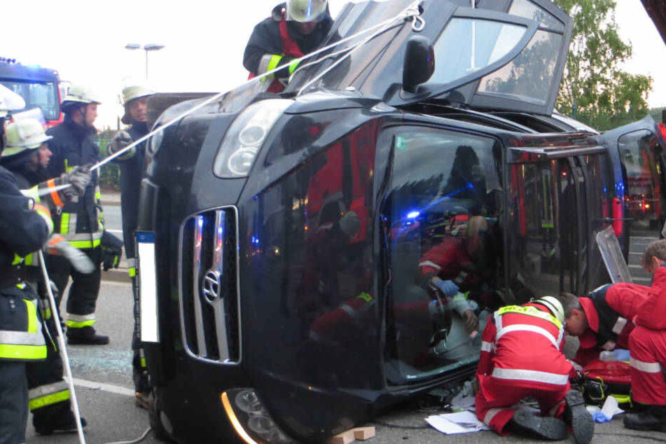 Die Feuerwehrleute versuchen, den Fahrer aus seinem Auto zu befreien.