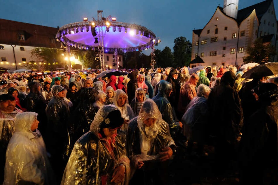 Besucher der MDR-Open-Air-Show "Die Schlager des Sommers" verlassen den Hof von Schloss Klaffenbach. Wegen eines heftigen Gewitters musste die Aufzeichnung unterbrochen werden.