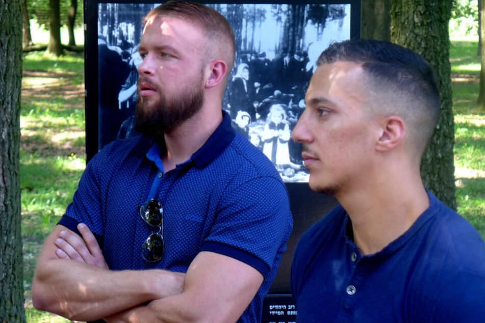 Kollegah und Farid Bang stehen in der Nähe der Ruinen von Gaskammer und Krematorium.