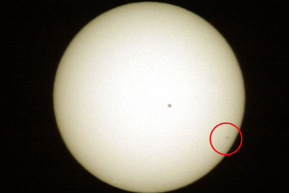 Der Planet Merkur ist am 07.05.2003 rechts unten als winziger schwarzer Punkt vor der Sonne zu sehen, in der Mitte ein Sonnenfleck.