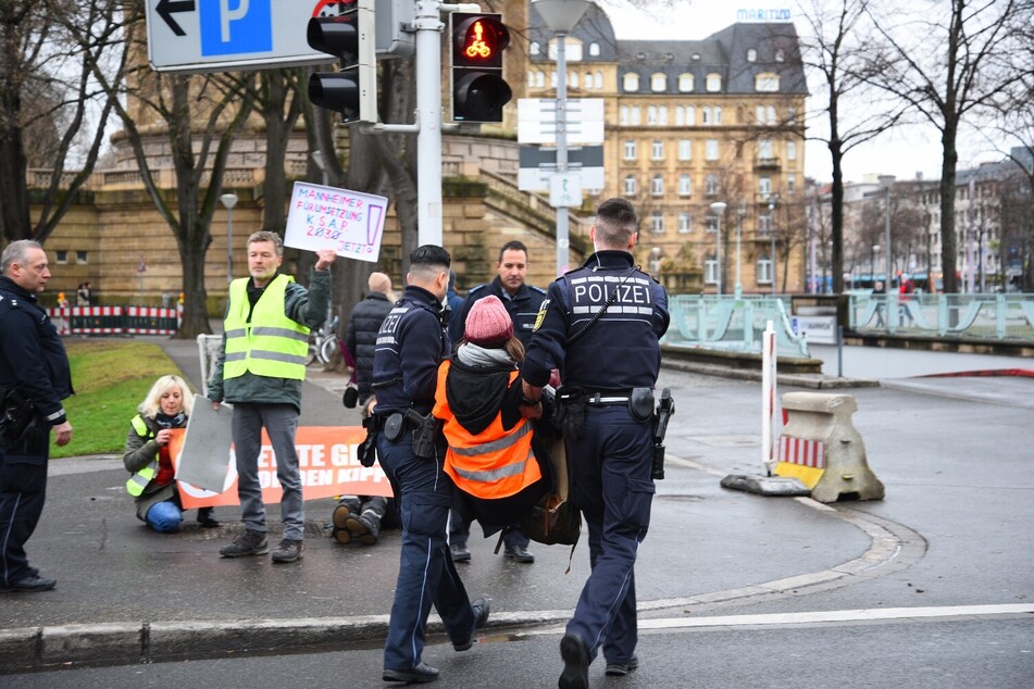 Die Polizeibeamten tragen einen Aktivisten von der Straße.