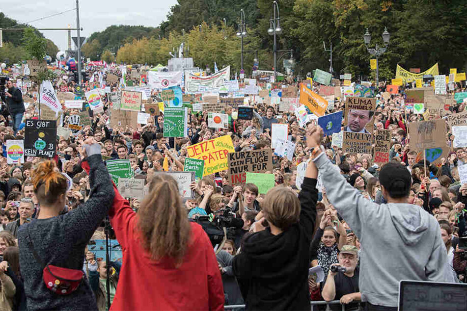 Demonstranten nehmen am Klima Protesttag von Fridays For Future vor dem Brandenburger Tor teil und stehen vor der Bühne.