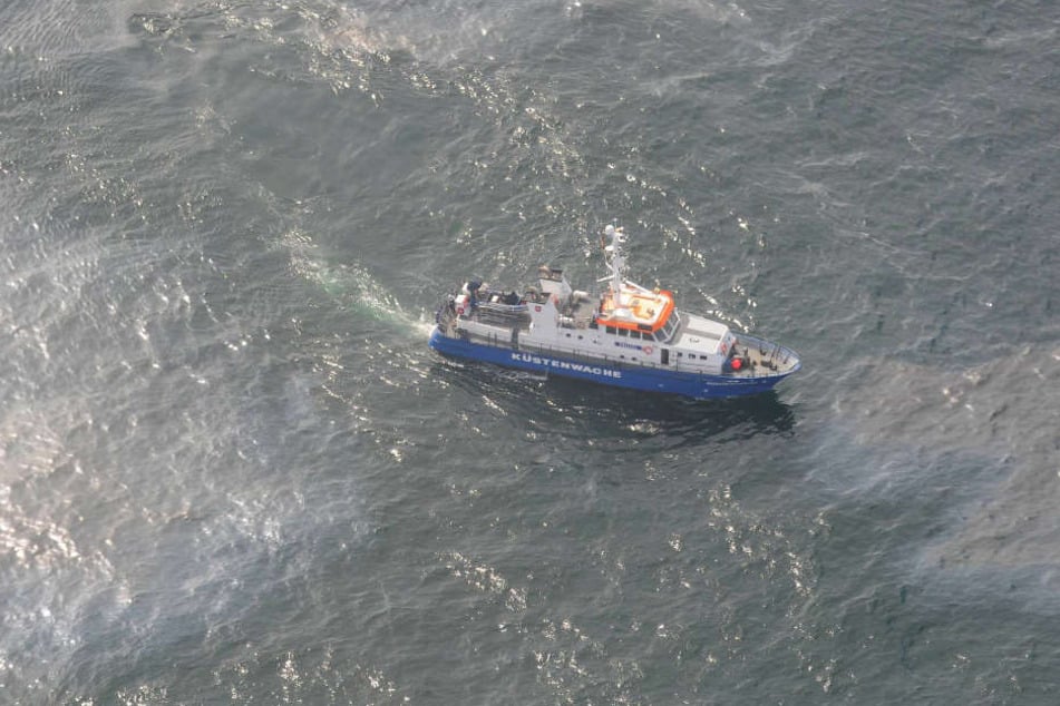 Ein Schiff der Küstenwache durchfährt den verschmutzten Bereich.