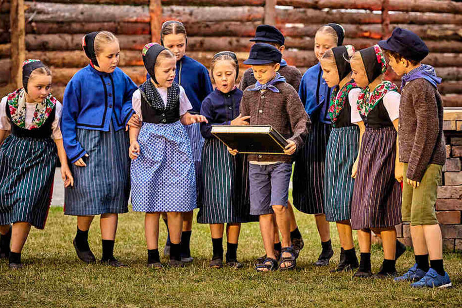 Eine Kinderschar in sorbischer Tracht spielt bei den Krabat-Festspielen in Schwarzkollm mit.
