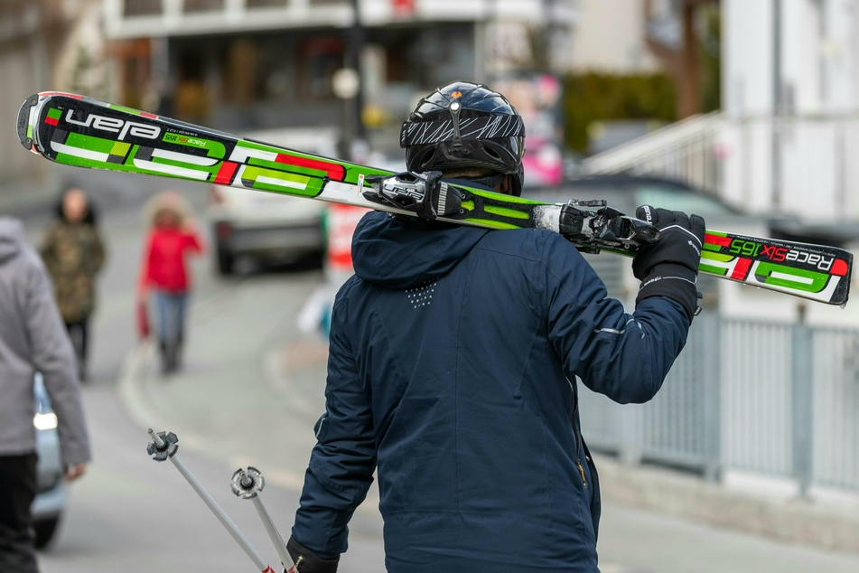 Ischgl: Ein Skifahrer geht mit geschulterten Skiern auf einer Straße.