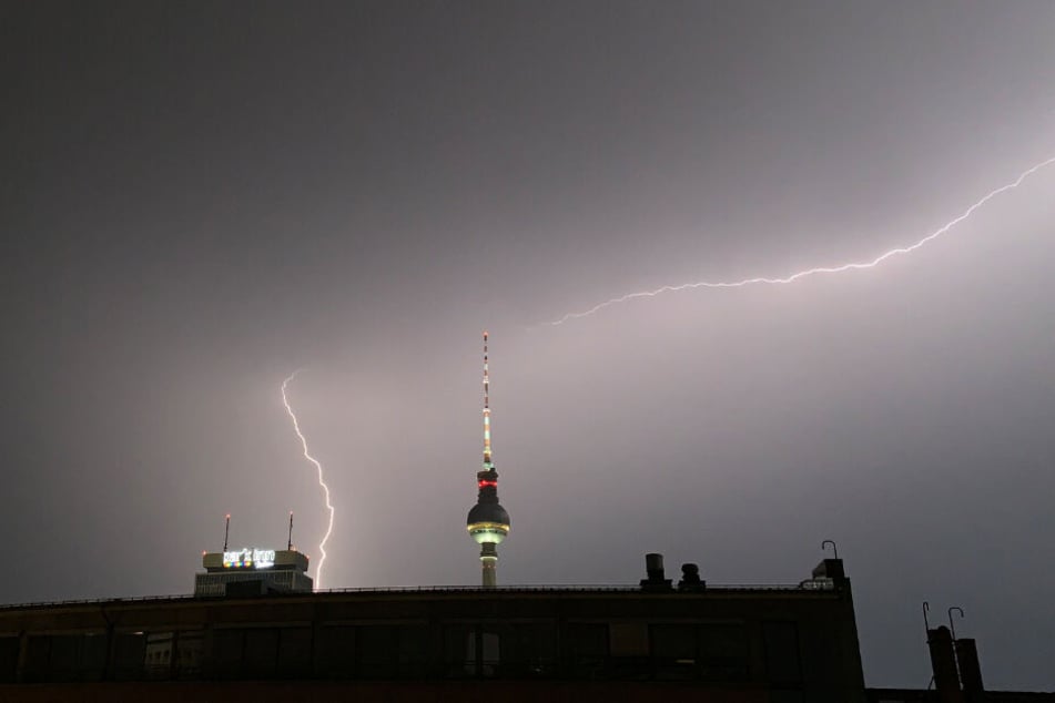 Blitze zucken während eines Gewitters über dem Fernsehturm.