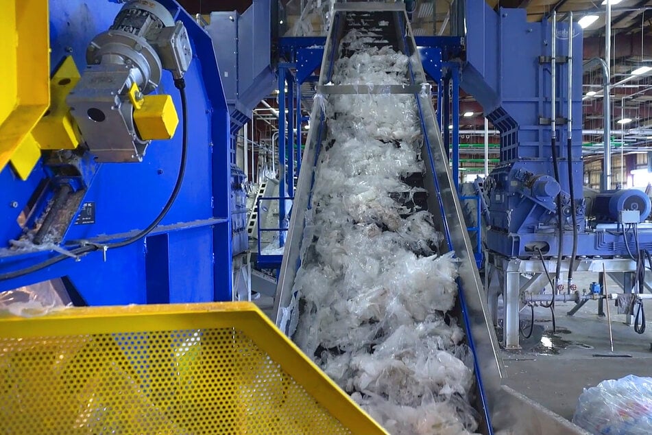 Shredded plastic moves along a conveyor belt before the next recycling step.