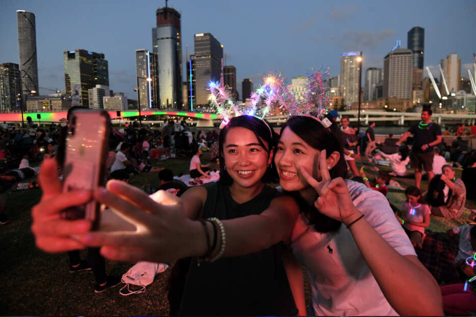 Brisbane: Mizuki (l) und Tsubasa machen ein Selfie, während sie auf den Start der Feuerwerksshow zum Jahreswechsel im Stadtteil South Bank warten.