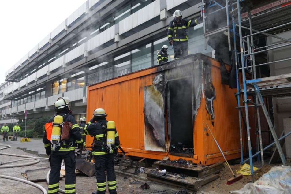 Einsatzkräfte löschen die brennenden Container.