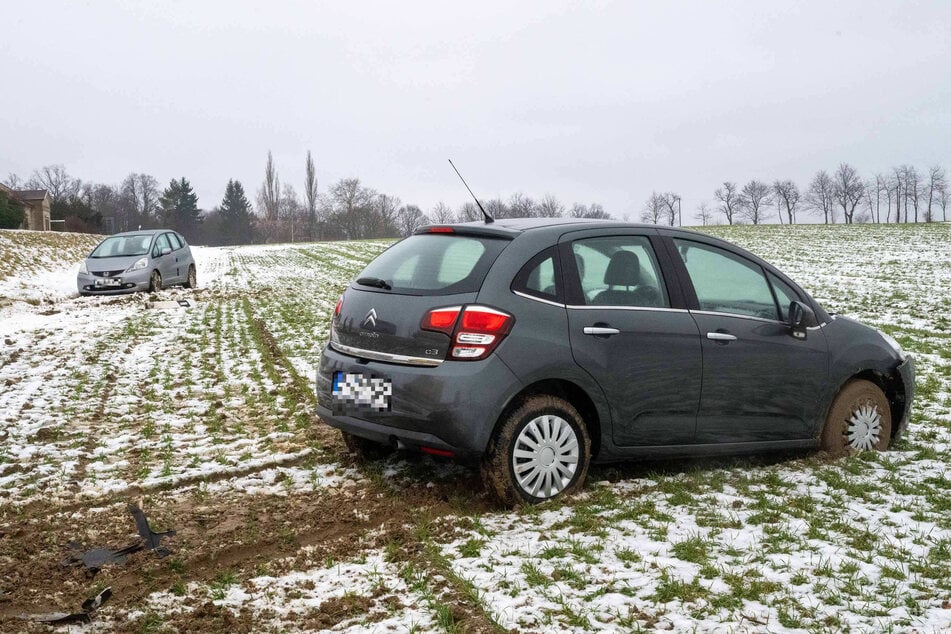 Die beiden beteiligten Autos, ein dunkelgrauer Citroën C3 als auch einen silberner Honda Civic, sind auf dem Feld gelandet.