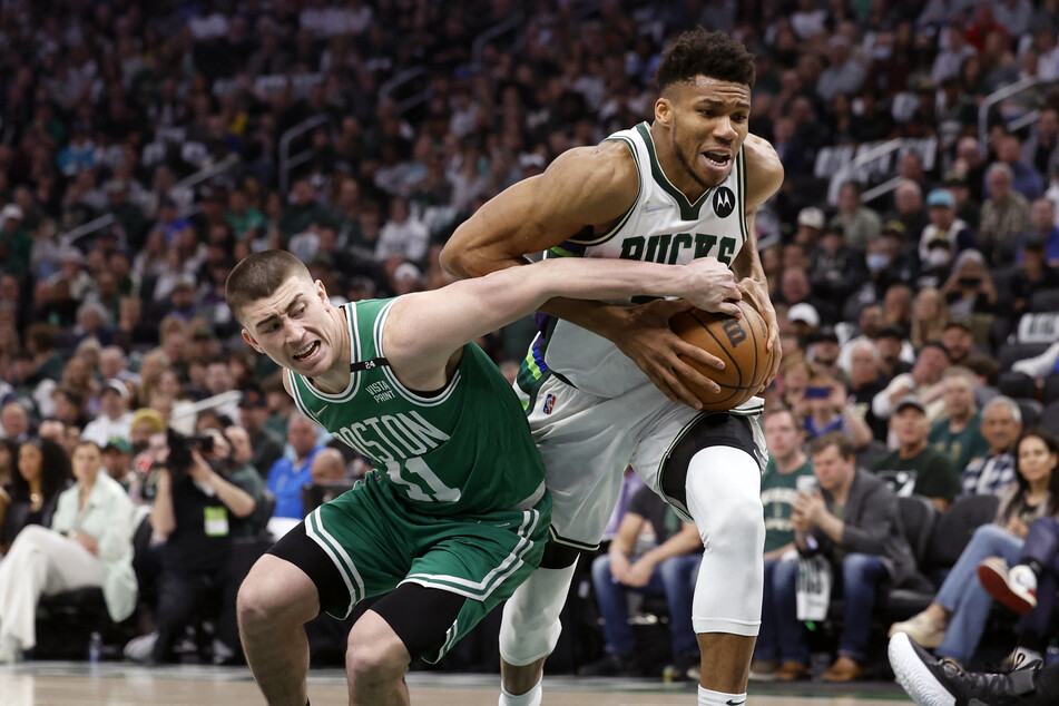 Celtics guard Payton Pritchard (l.) defends Bucks forward Giannis Antetokounmpo during game three of the second round of the 2022 NBA Playoffs.